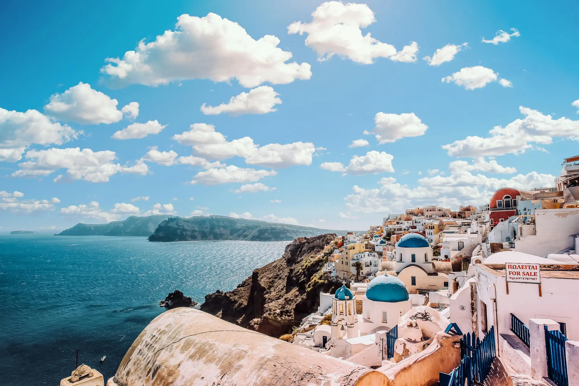 Le case bianche e le cupole azzurre di Oia, a Santorini, affacciate sul mare della caldera