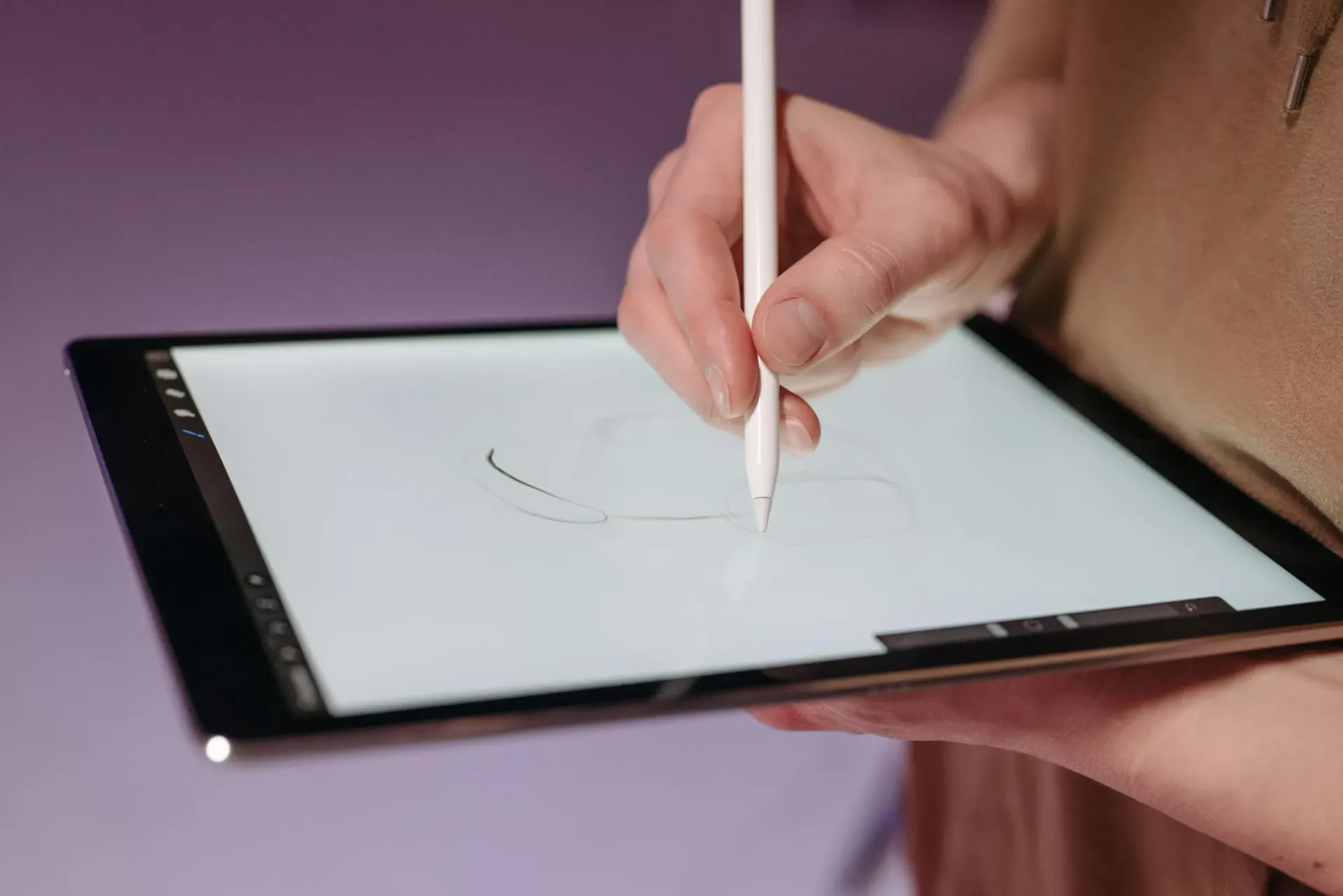 Una mano firma con il pennino sullo schermo di un tablet